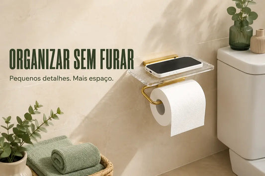 Porta-rolos dourado com prateleira e telemóvel numa casa de banho organizada sem furar azulejos.