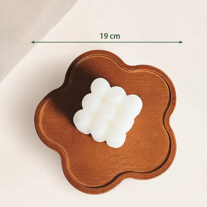 Tabuleiro de madeira em forma de flor com bordos elevados, acabamento natural e 19 cm de largura.
